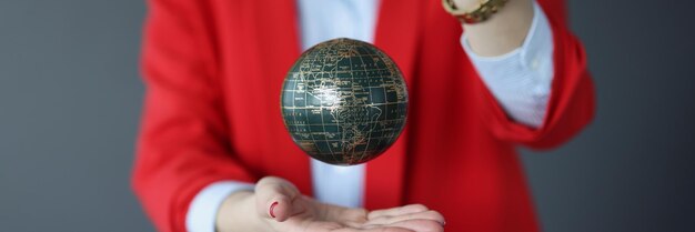 Женщина в деловом костюме держит мяч с картой мира, концепция мировой политики и дипломатии