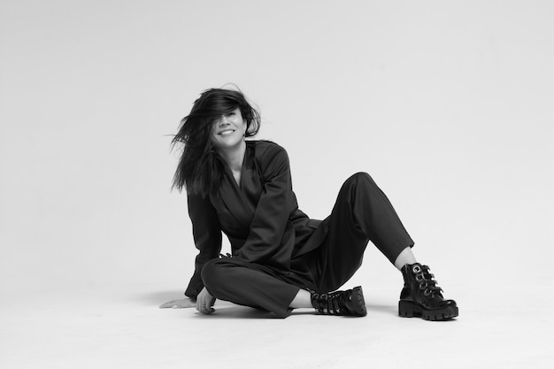 A woman in a business suit sits on white