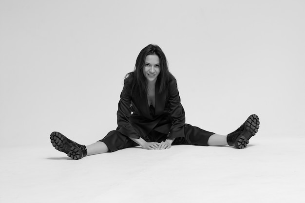 A woman in a business suit sits on white