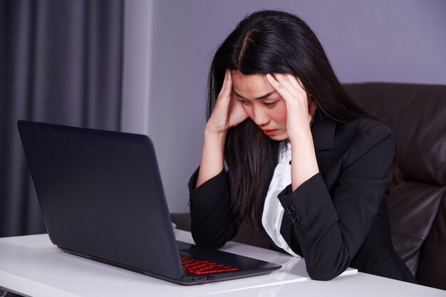 woman in business suit working with laptop in stress desperate 