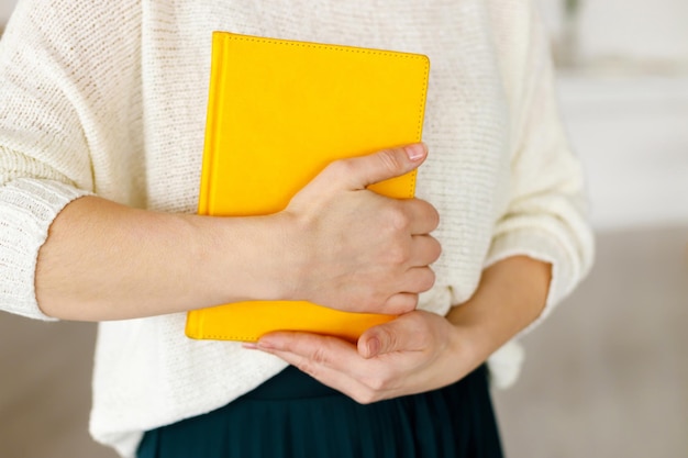 写真 黄色のメモ帳を保持している女性実業家日または週の事業計画とタスク