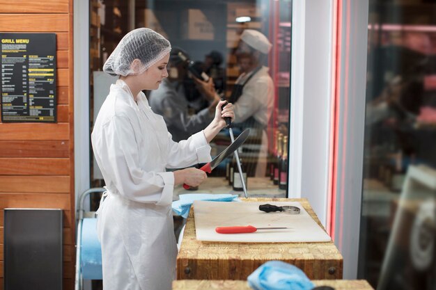 Woman in a butchery sharpening knife