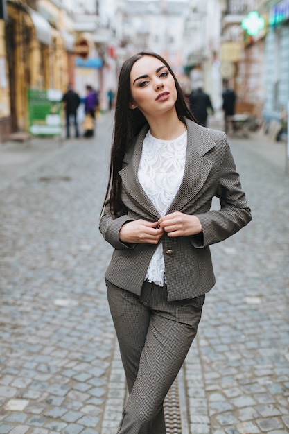 Woman buttoning jacket up on street