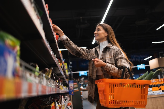 Женщина покупает продукты питания в супермаркете