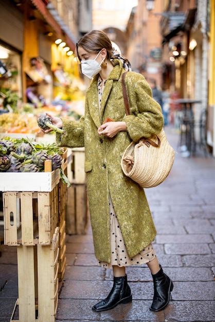 Foto donna che compra cibo sul mercato di strada durante la pandemia