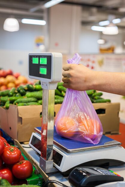 ストリートマーケットで新鮮な野菜を買う女性