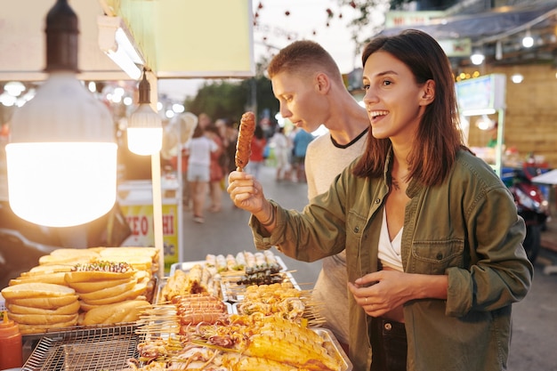 Woman buying grilled pork skewer