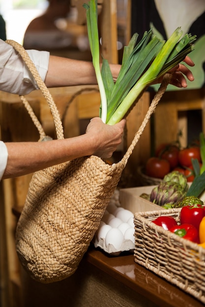 Woman buying leafy vegetable at organic section