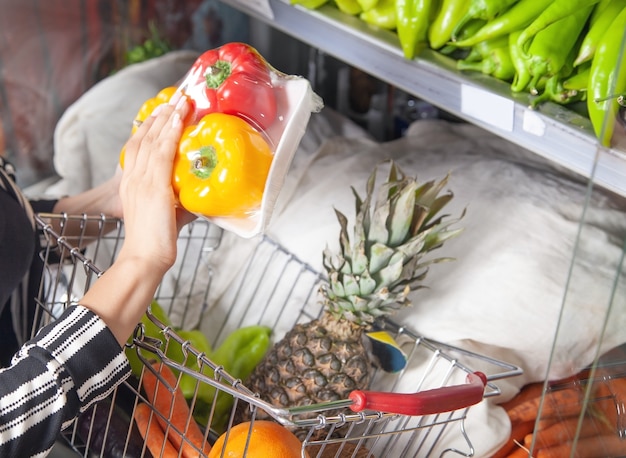 Woman buying pepper at food store.