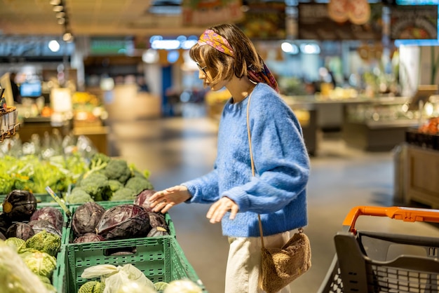 Donna che compra le verdure in supermercato