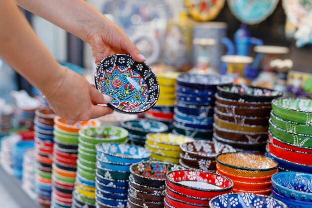 女性が東洋のバザールで陶器の皿を買う