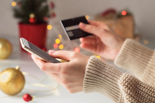 A woman buys gifts for her loved ones for christmas pays for purchases with a credit card via phone