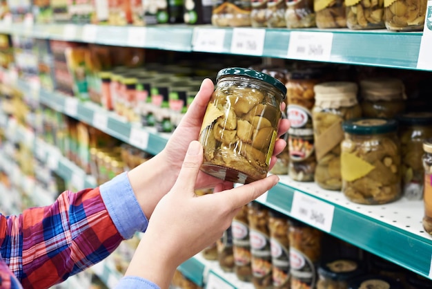 Woman buys salted mushrooms in the store