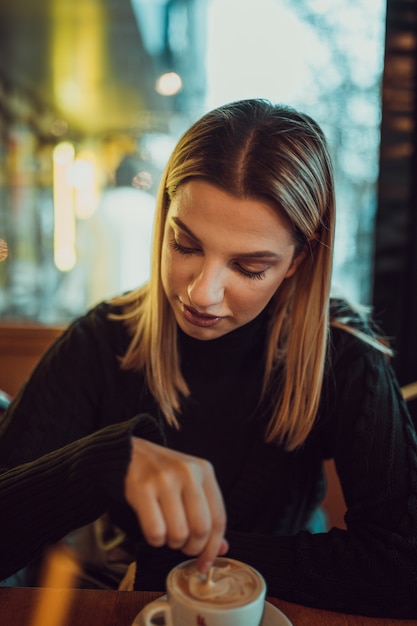 Donna in un caffè che beve caffè