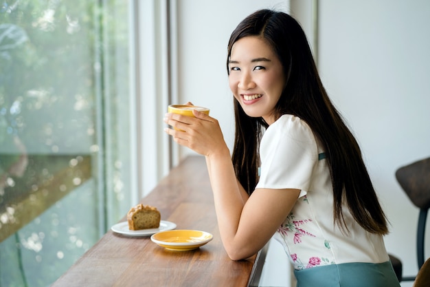 コーヒーを飲みながらカフェの女性