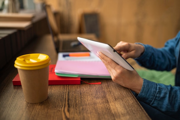 Photo woman at cafe waiting for her friends to arrive to do homework