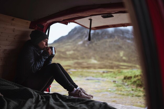 Photo woman in a camper sipping coffee