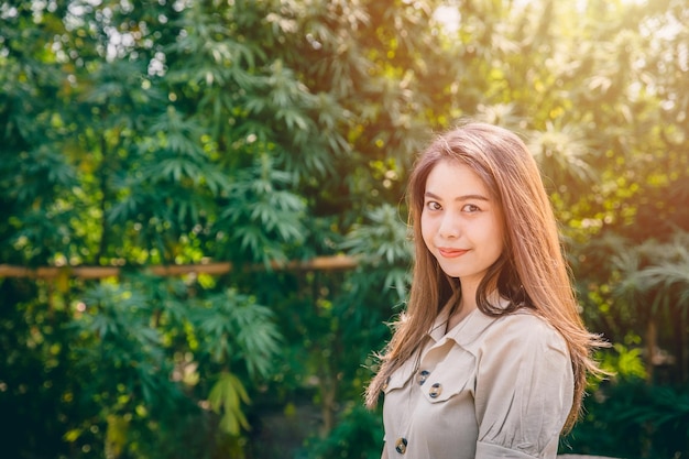 大麻農業農場の女性マリファナまたは麻の緑のハーブ植物の幸せな笑顔を持つ女の子の十代