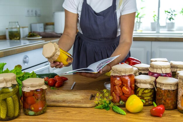 写真 キッチンで野菜を瓶にめ込む女性 選択的な焦点