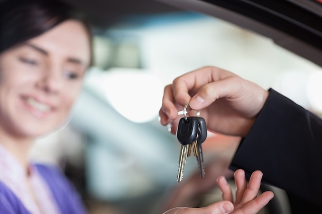 キーを受け取る車の女性