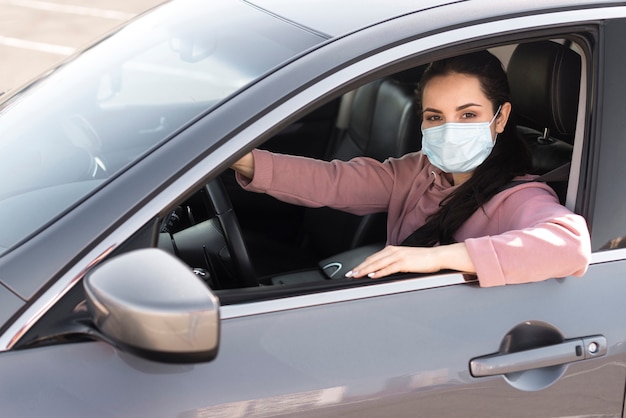 防護マスクを身に着けている車の中で女性