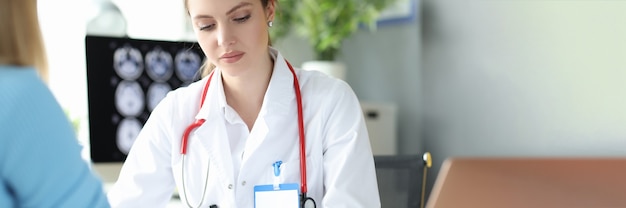 Woman cardiologist measuring blood pressure to patient in clinic