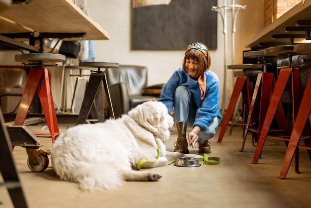 Woman cares her dog at modern coffee shop