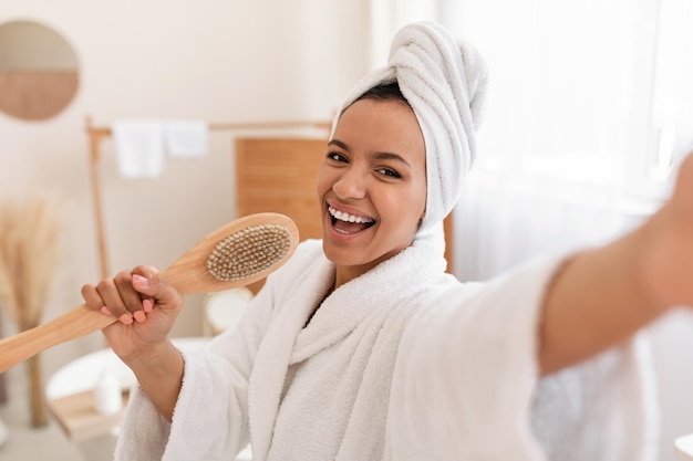 Woman Caring For Body Singing Holding Wooden Brush In Bathroom