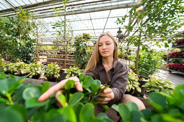 Woman caring for plants in a greenhouse