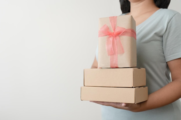 Woman carrying gift paper box tie cute ribbon for special occasion