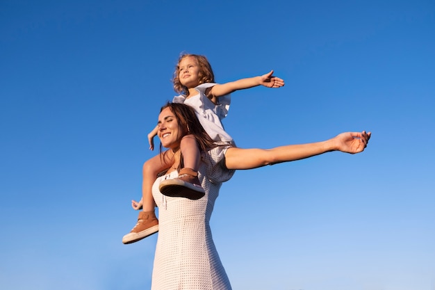 Photo woman carrying girl low angle