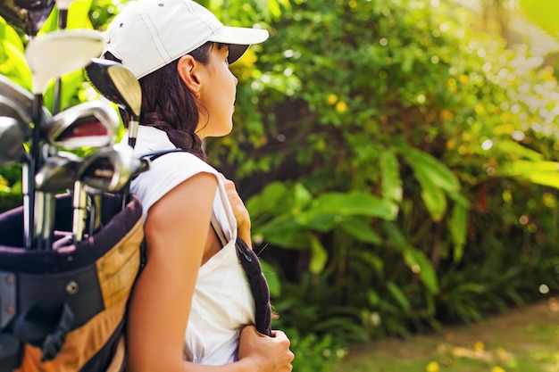 Woman carrying golf equipment