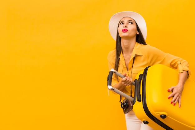 Woman carrying heavy trip luggage with copy space