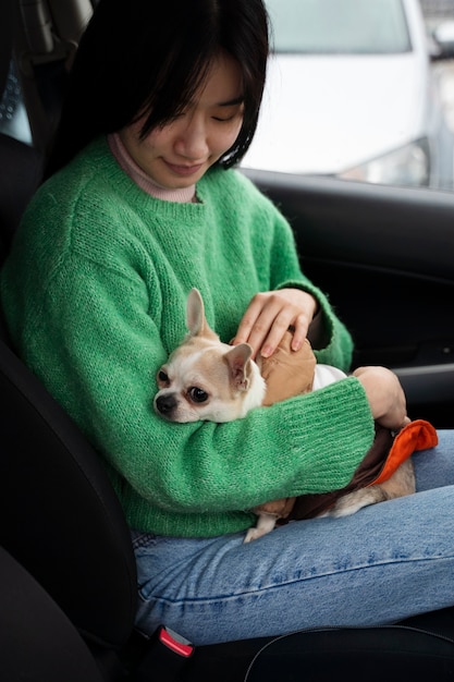 Foto donna che porta il suo animale domestico in macchina