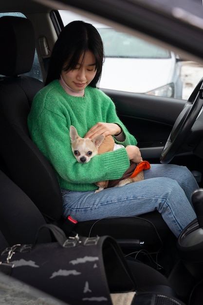 그녀의 애완 동물을 차에 태우고 있는 여자