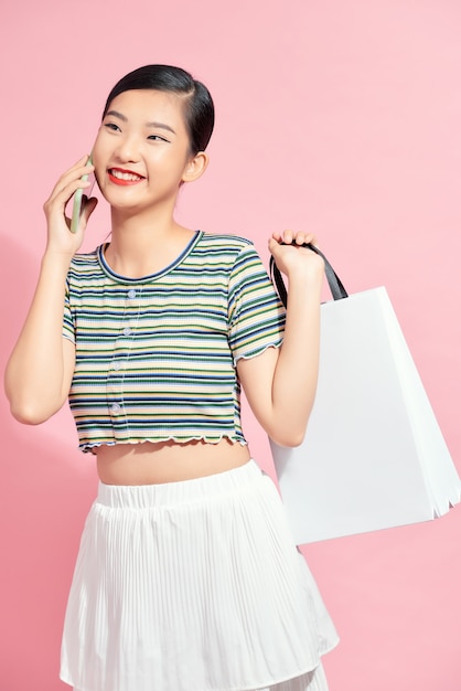 Woman carrying shopping bags and talking on mobile phone