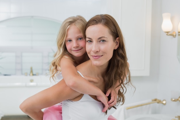 Woman carrying young girl in the house