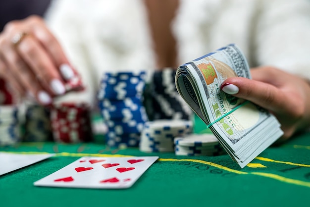 Woman in a casino with many chips that she wraps after a big poker win