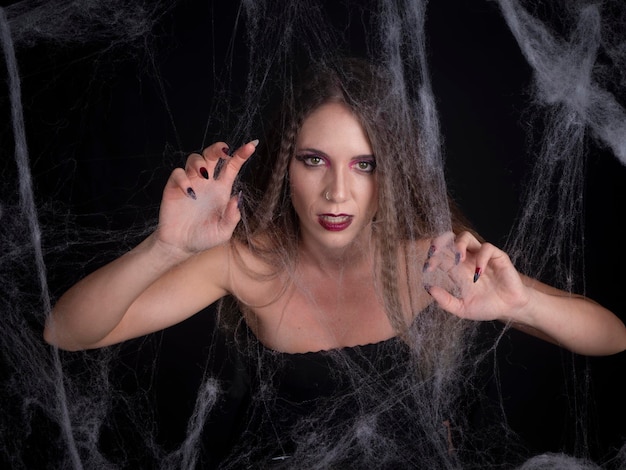 Woman casting a spell between spider webs