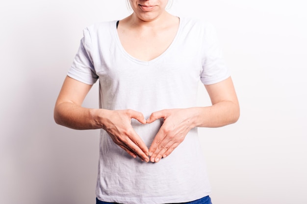 woman in casual clothing shows heart in abdomen Period or pregnancy concept women health