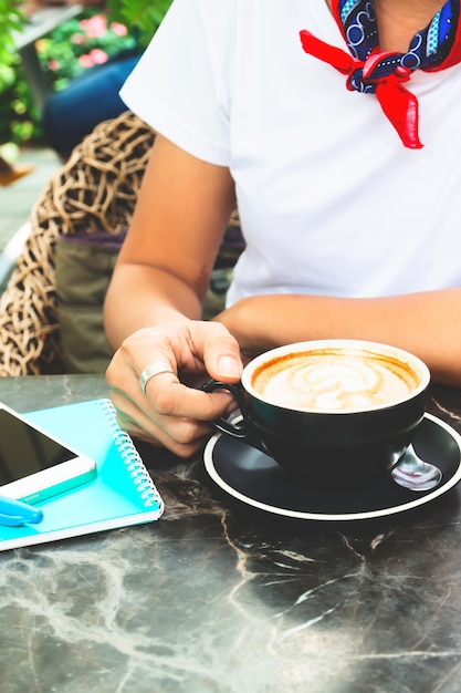 Woman in casual style white t-shirt drinking coffee