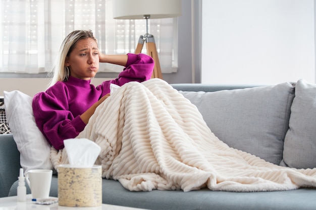 Woman Caught Cold and Flu Sneezing into Tissue.