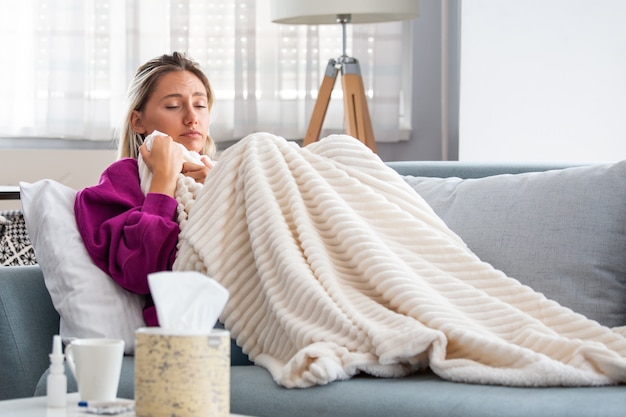 Donna catturata raffreddore e influenza starnuti nel tessuto.