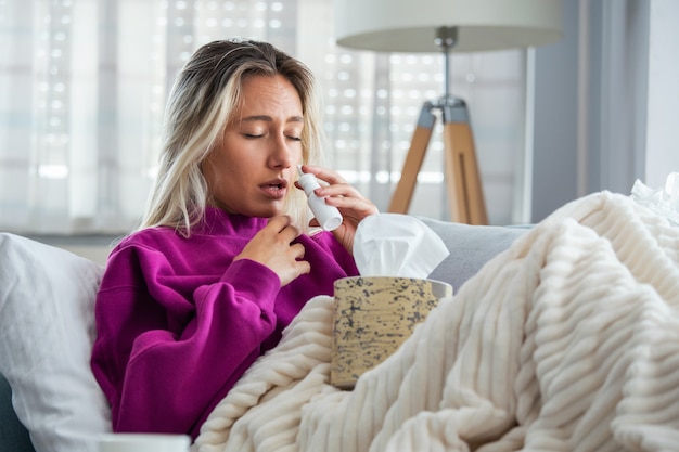 Woman Caught Cold and Flu Sneezing into Tissue.