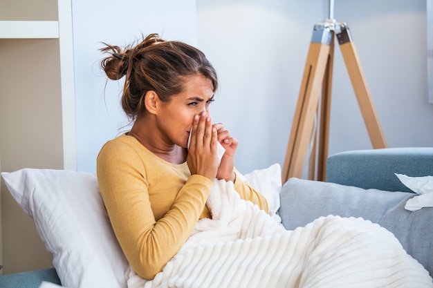 Donna catturata raffreddore e influenza starnuti nel tessuto.