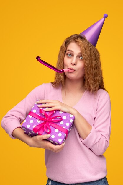 Woman celebrating birthday blowing party horn