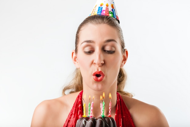 Woman celebrating birthday with cake and candles