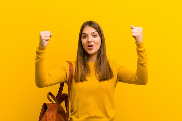 woman celebrating an unbelievable success like a winner, looking excited and happy saying take that!