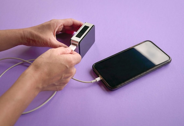 Photo woman charging cellphone with a power bank