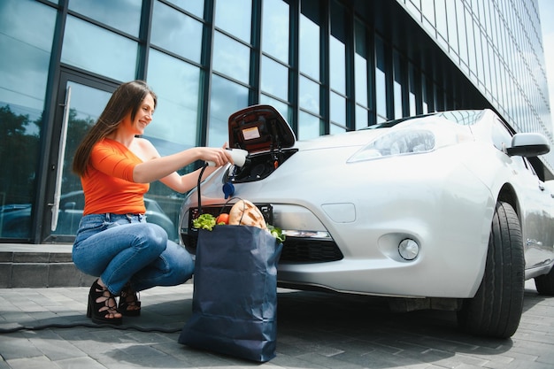 Woman charging electro car at the electric gas station